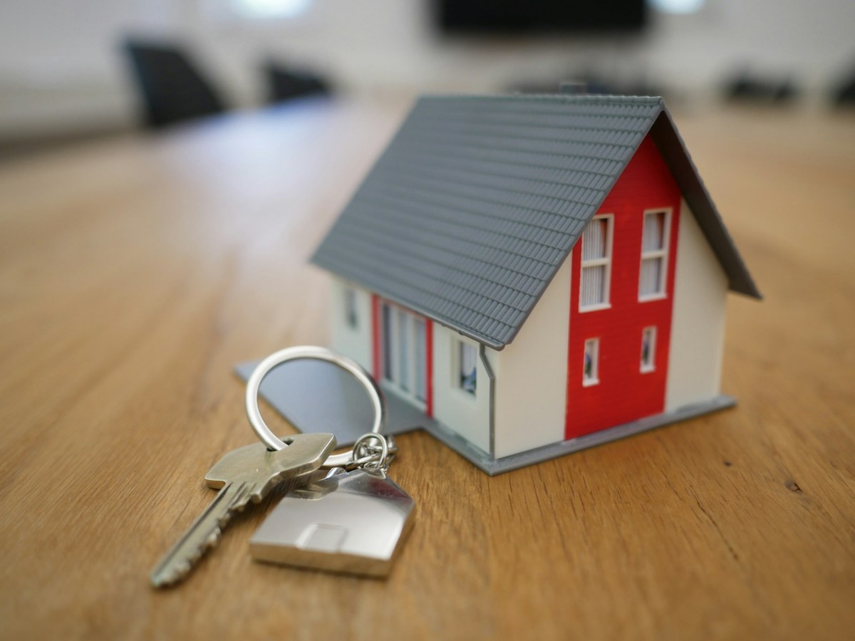 House keys and miniature home on a closing table