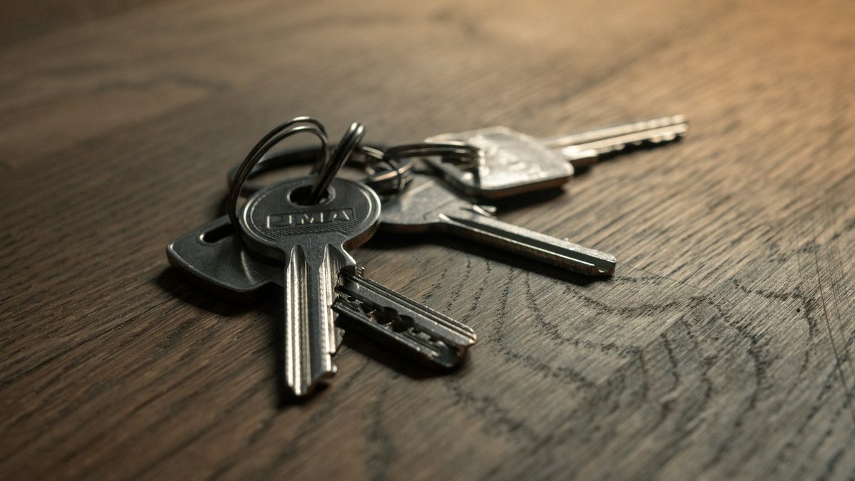 House keys on a wooden table representing closing day after negotiating seller concessions or a rate buydown
