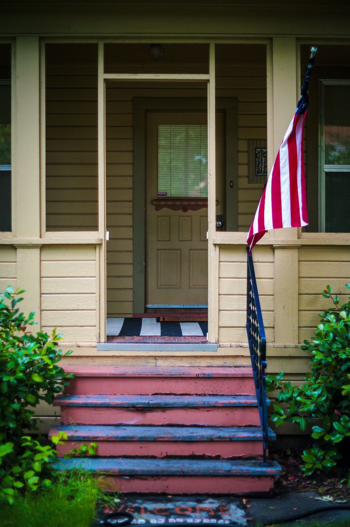 Front porch and steps of a traditional American home with a welcome mat, illustrating a resale house ready for buyer negotiations