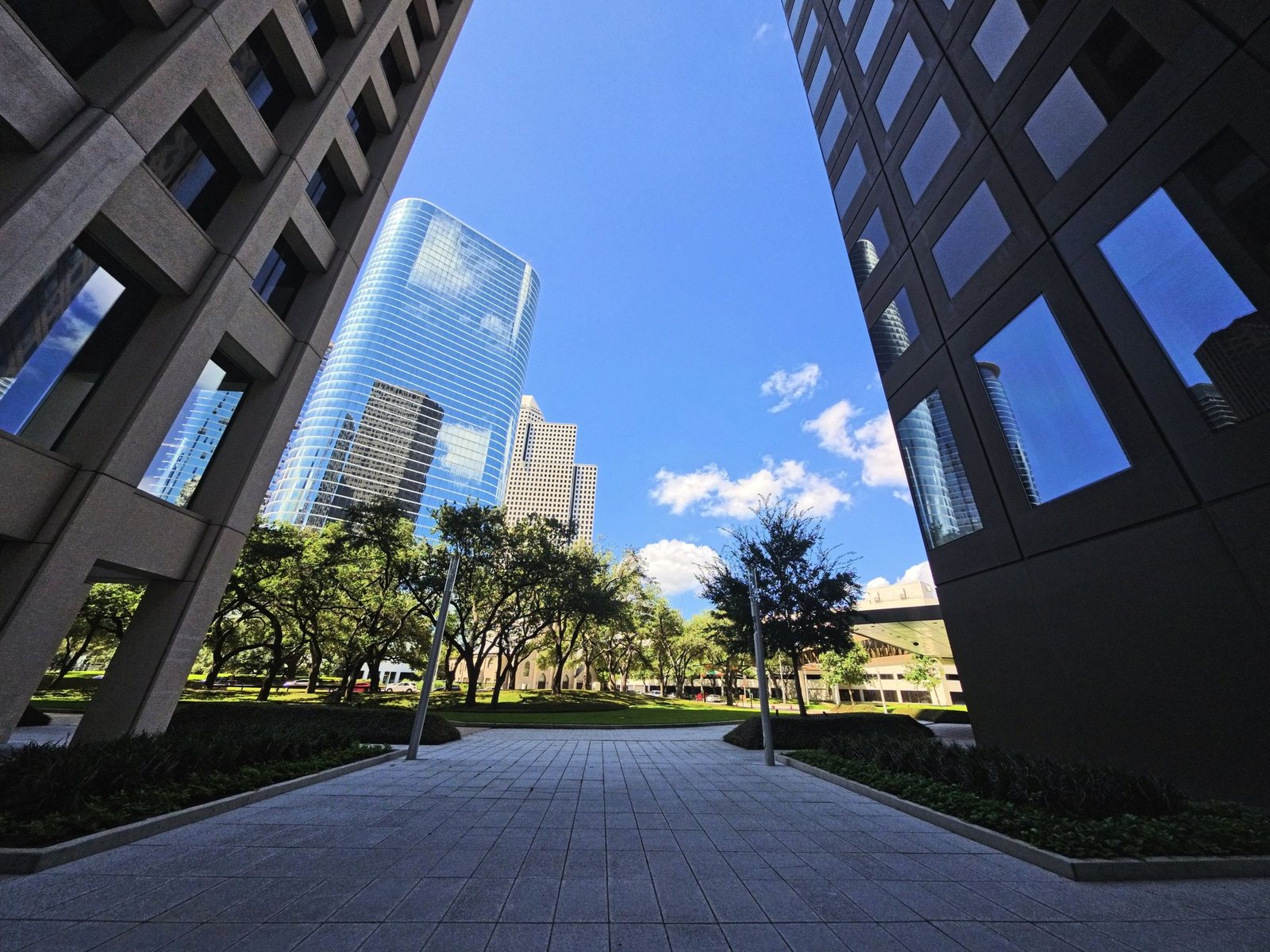 Low-angle view of modern glass commercial towers against a blue sky