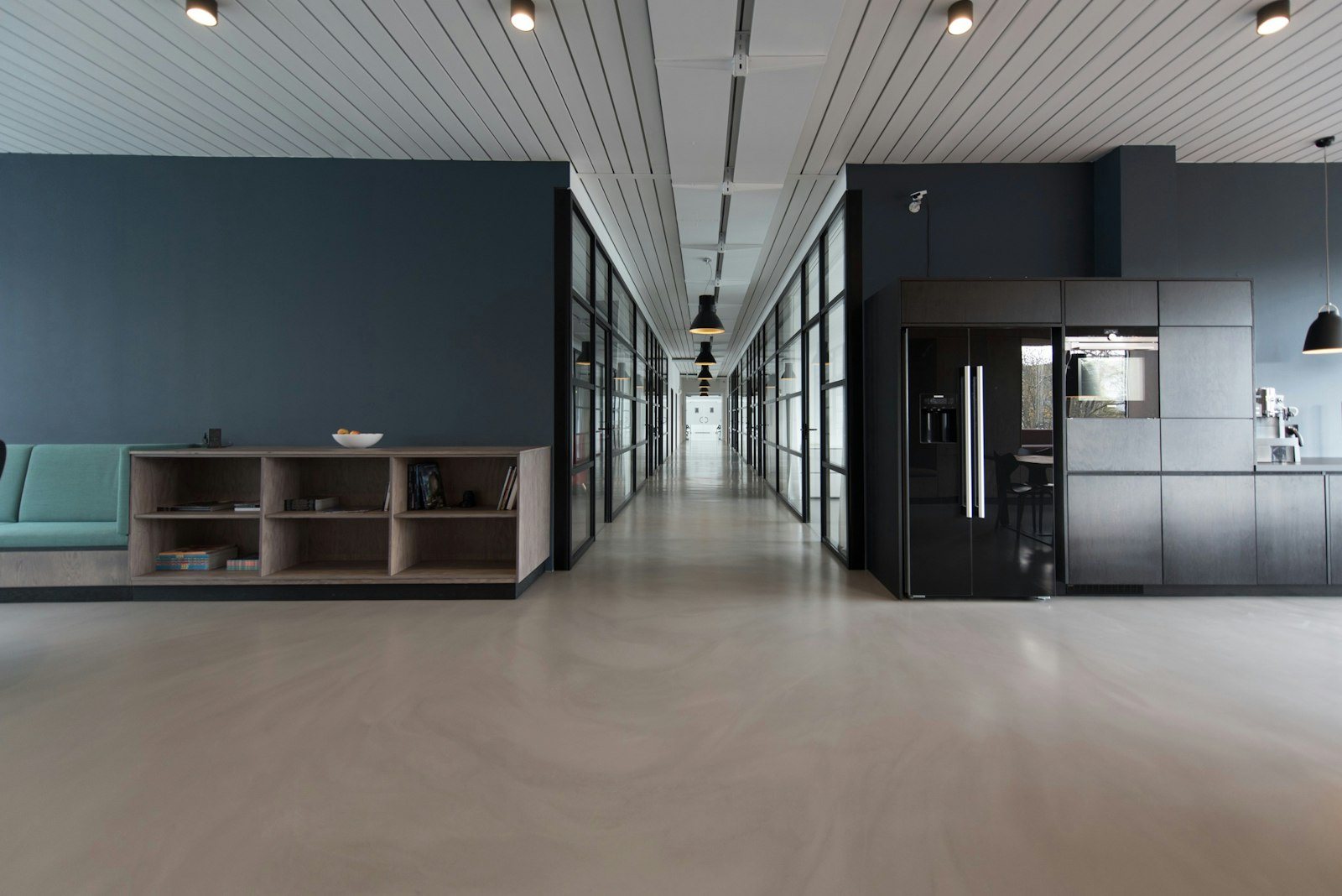 Modern open-plan office interior with desks and glass walls