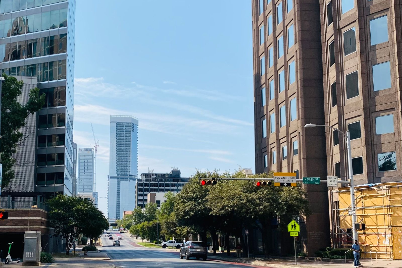 Urban street lined with multi-story commercial buildings under a clear sky