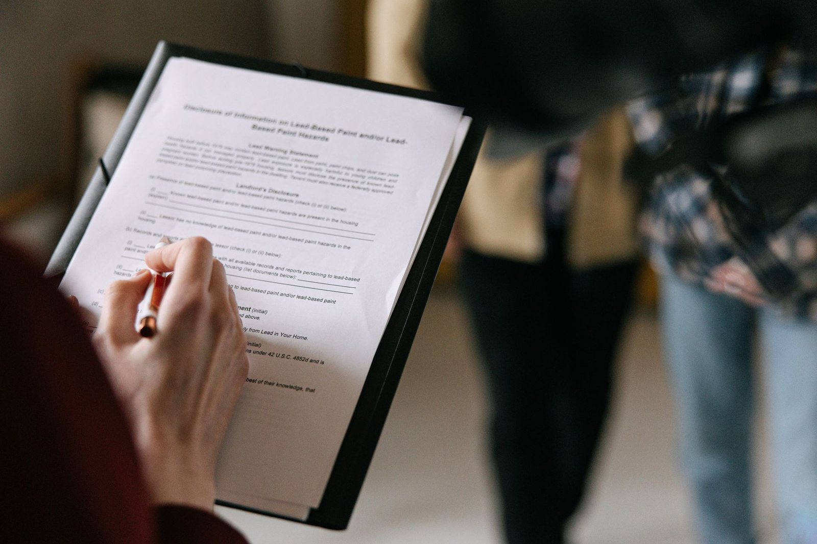 Borrower reviewing and signing a mortgage document on a clipboard