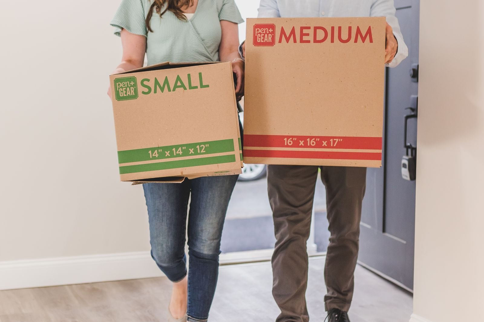 New homeowners carrying moving boxes into their first home