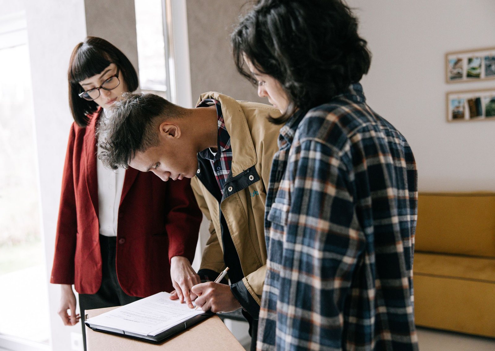 Mortgage advisor reviewing loan documents with a young couple in a bright office