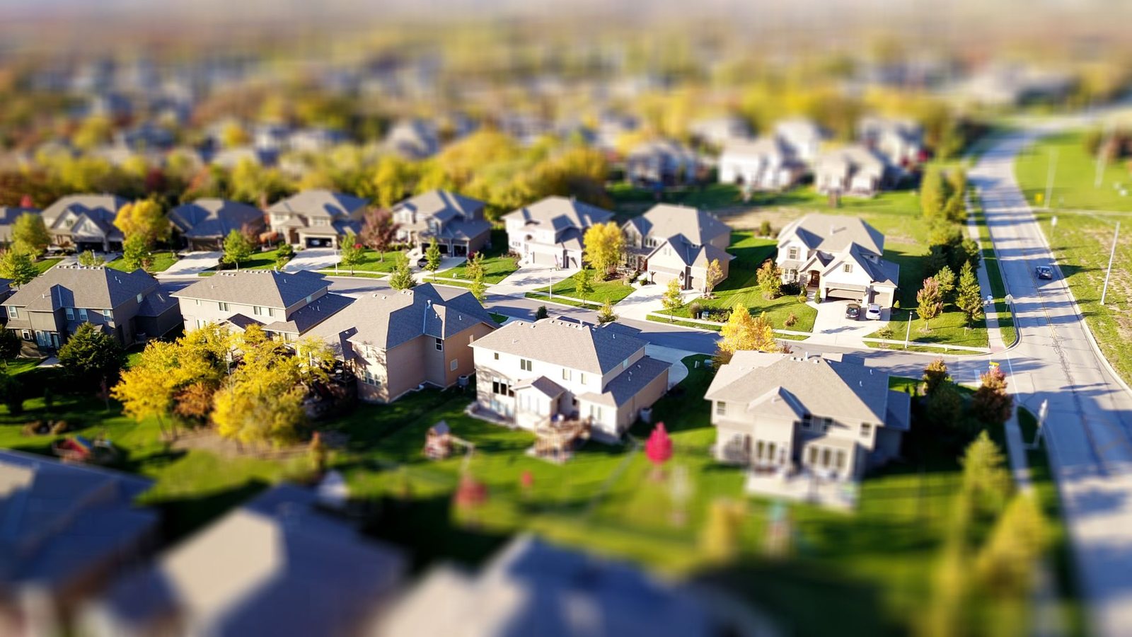 Aerial view of a suburban neighborhood with rows of houses and green lawns