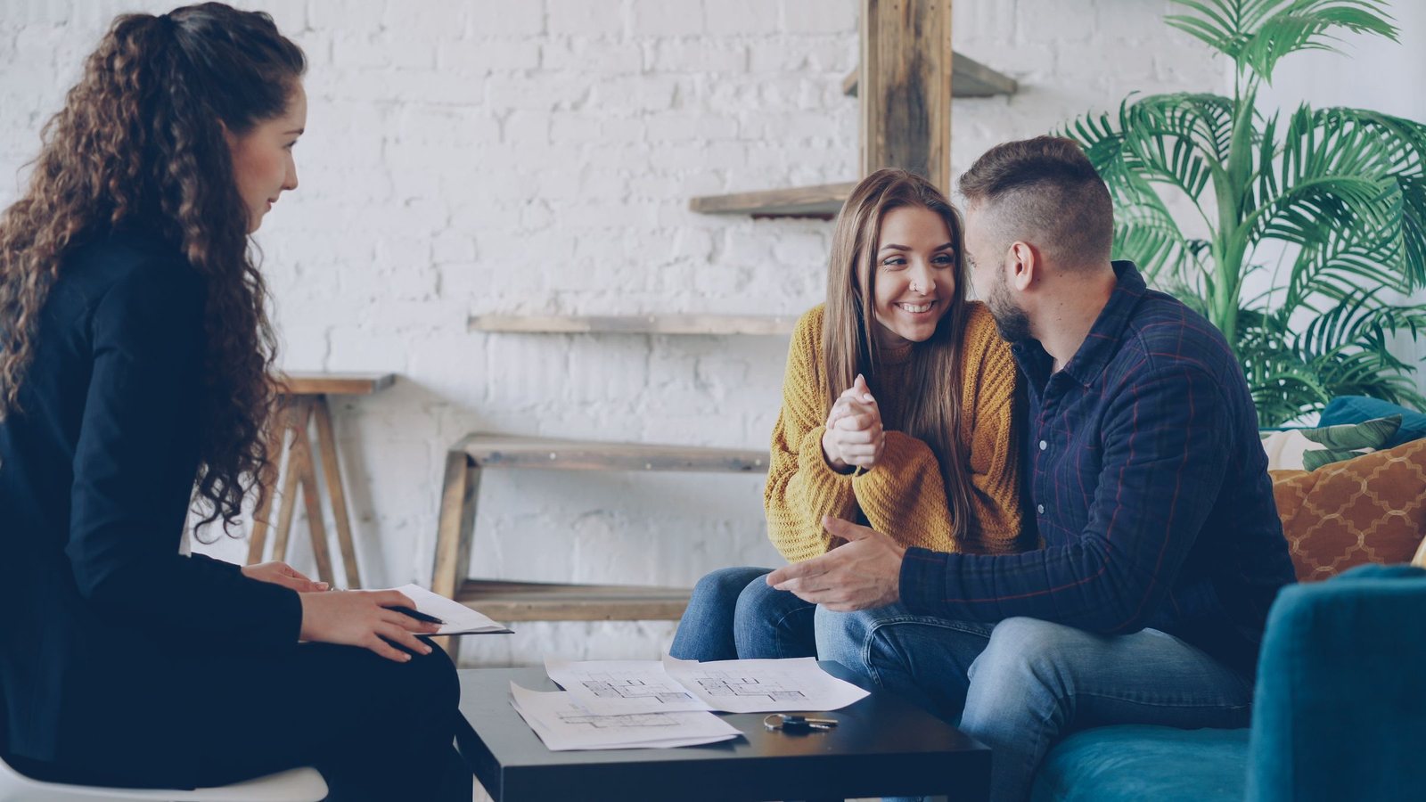 Couple on a sofa meeting with an advisor in a bright living room