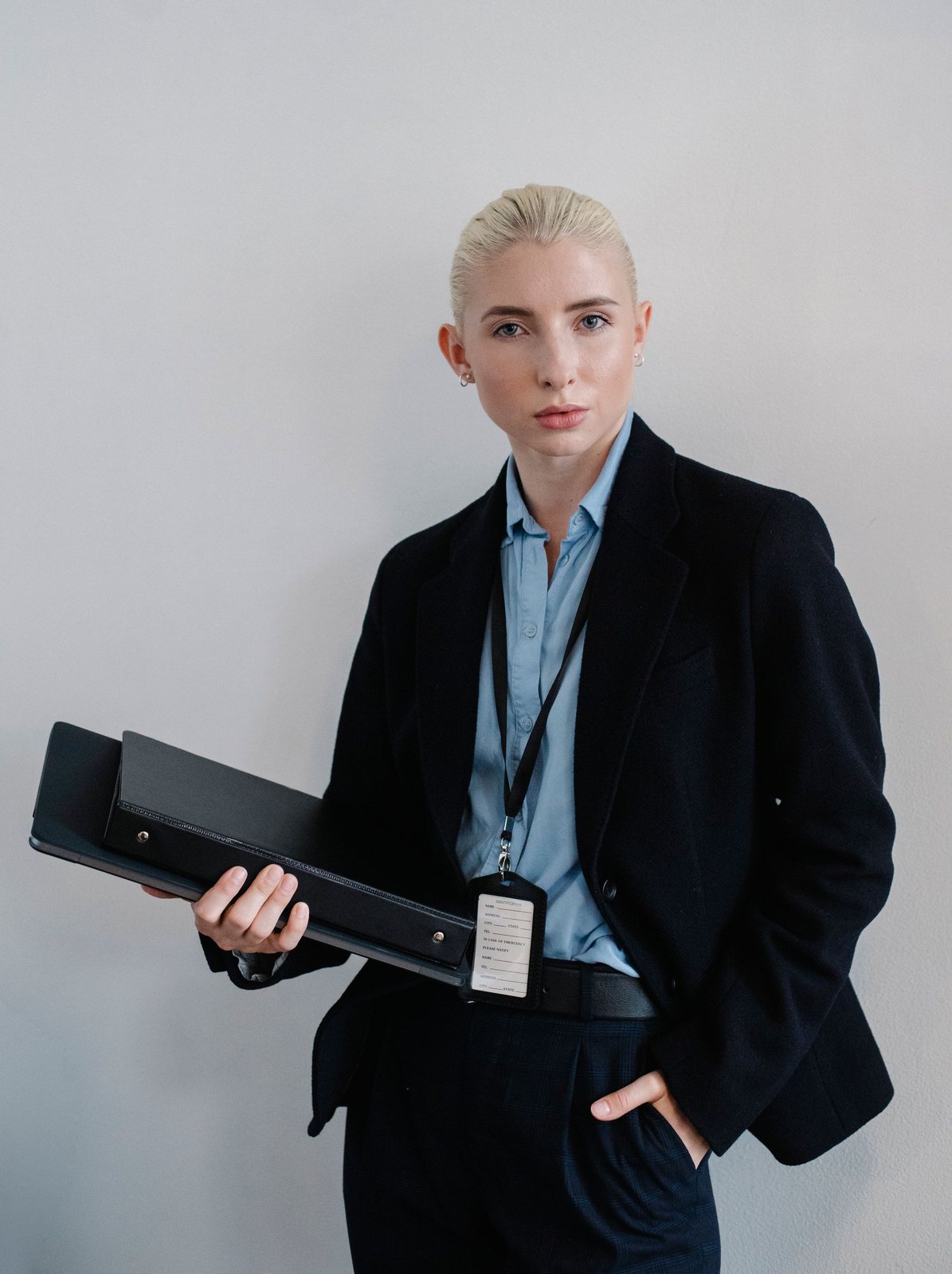 Professional in a dark suit holding a folder