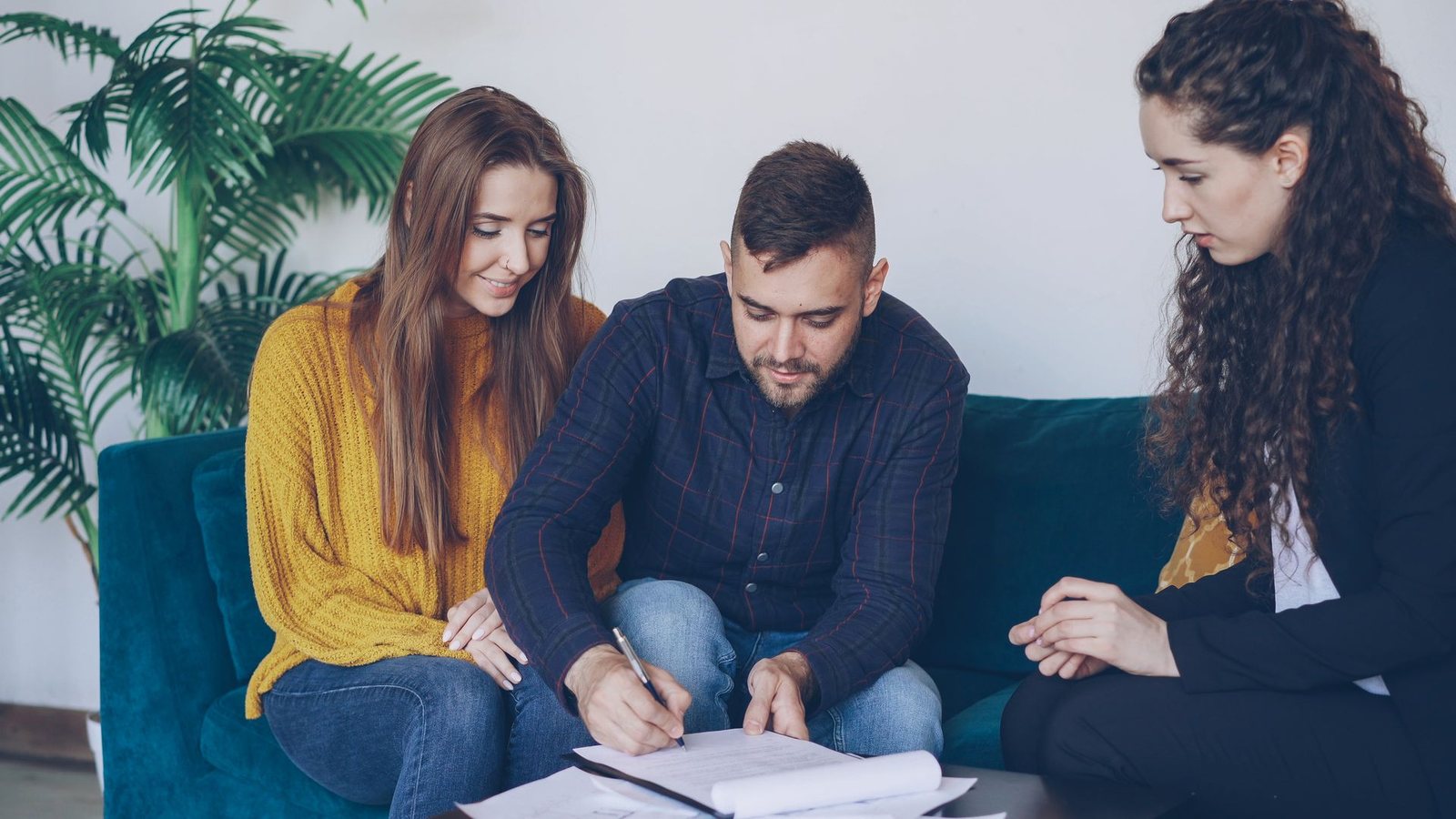 Couple reviewing documents with an advisor on a couch