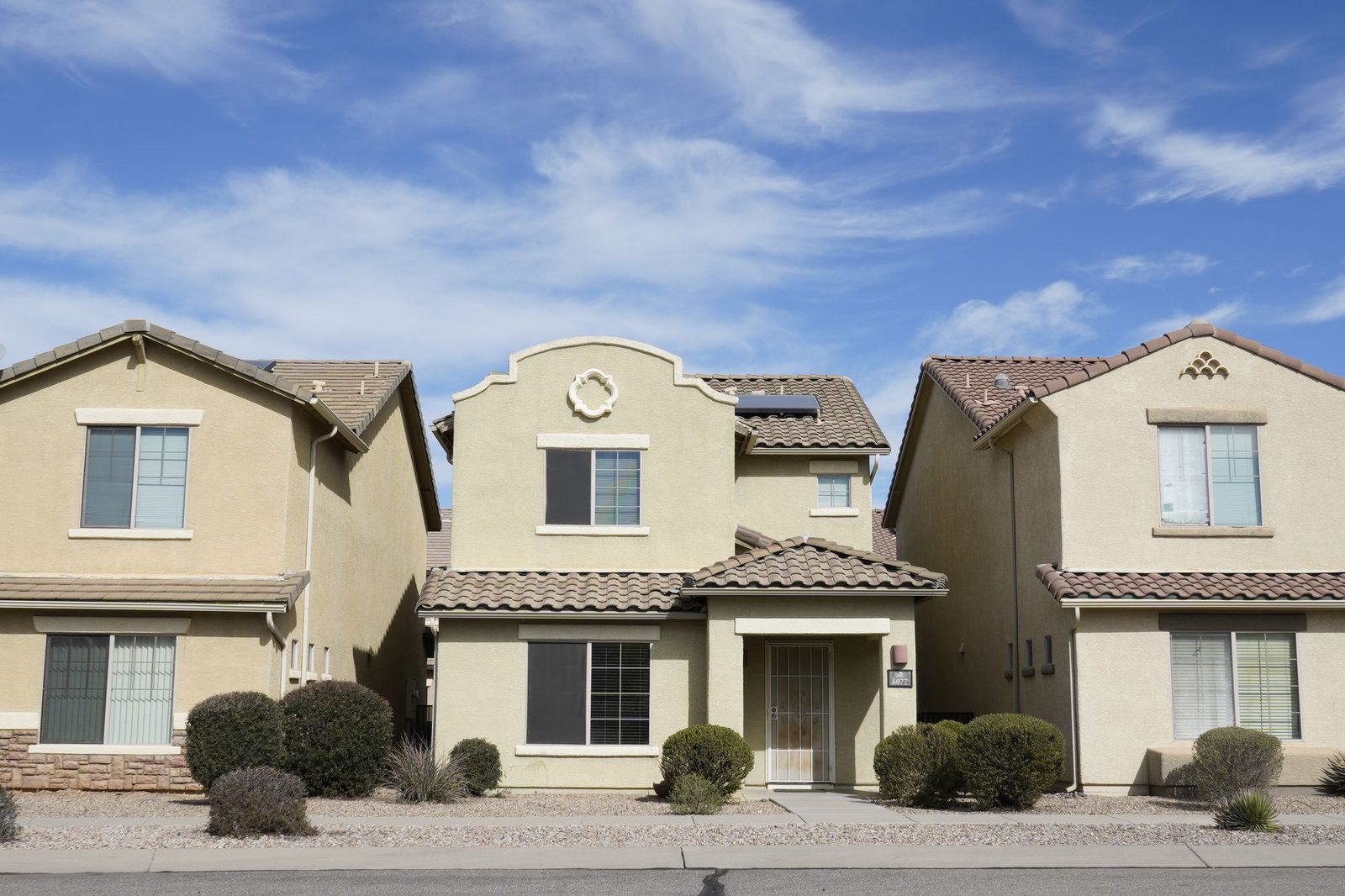 Row of Tucson area homes with stucco walls, tile roofs, and desert landscaping