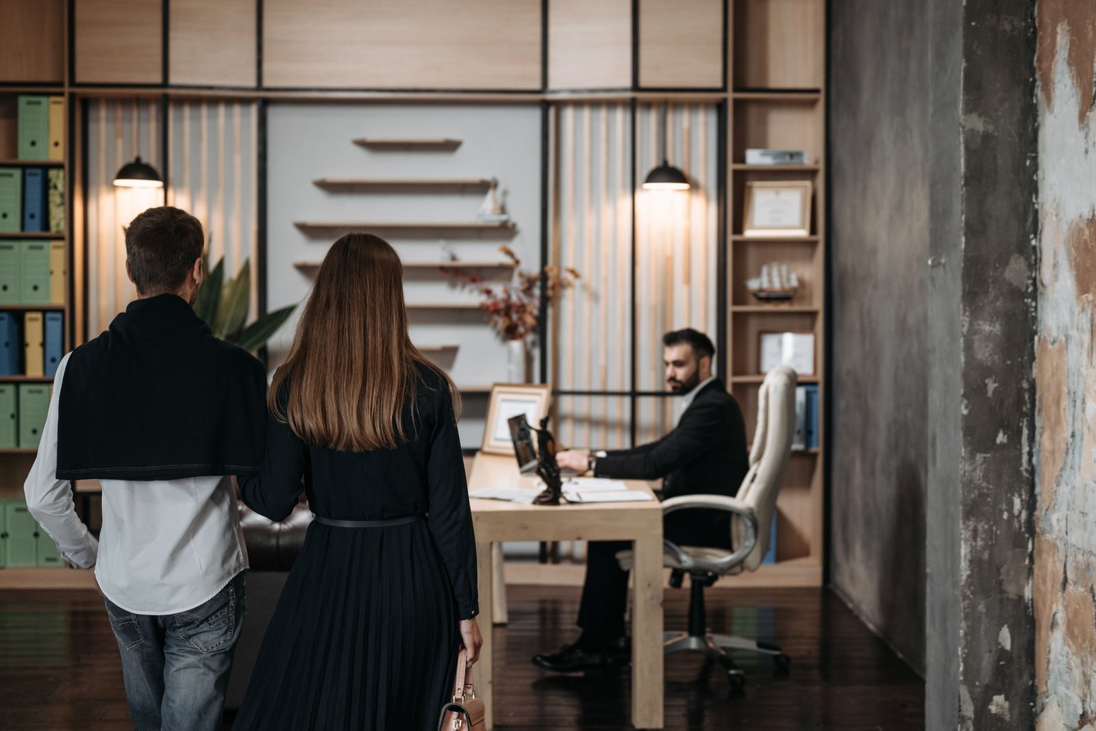 A couple standing at a loan advisor's desk in a modern office