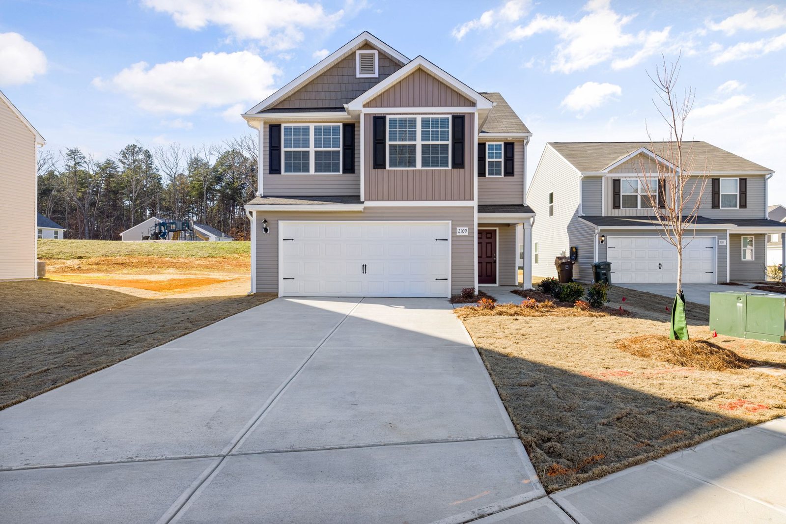 A new two-story house with an attached garage and a concrete driveway