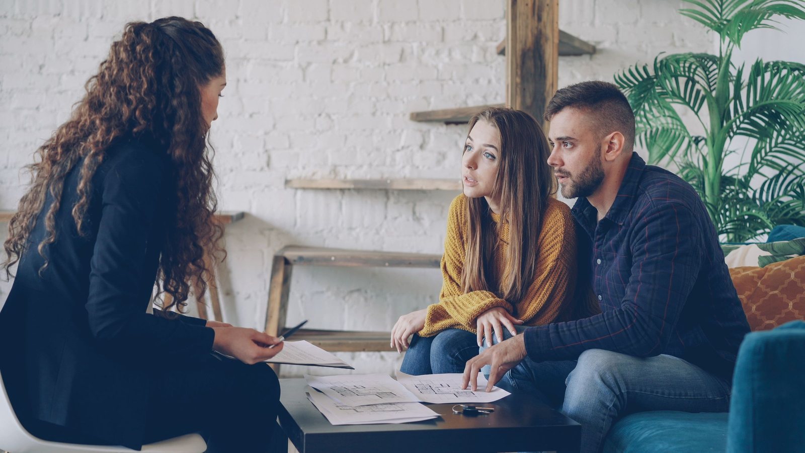 Couple reviewing plans with an advisor at a low table