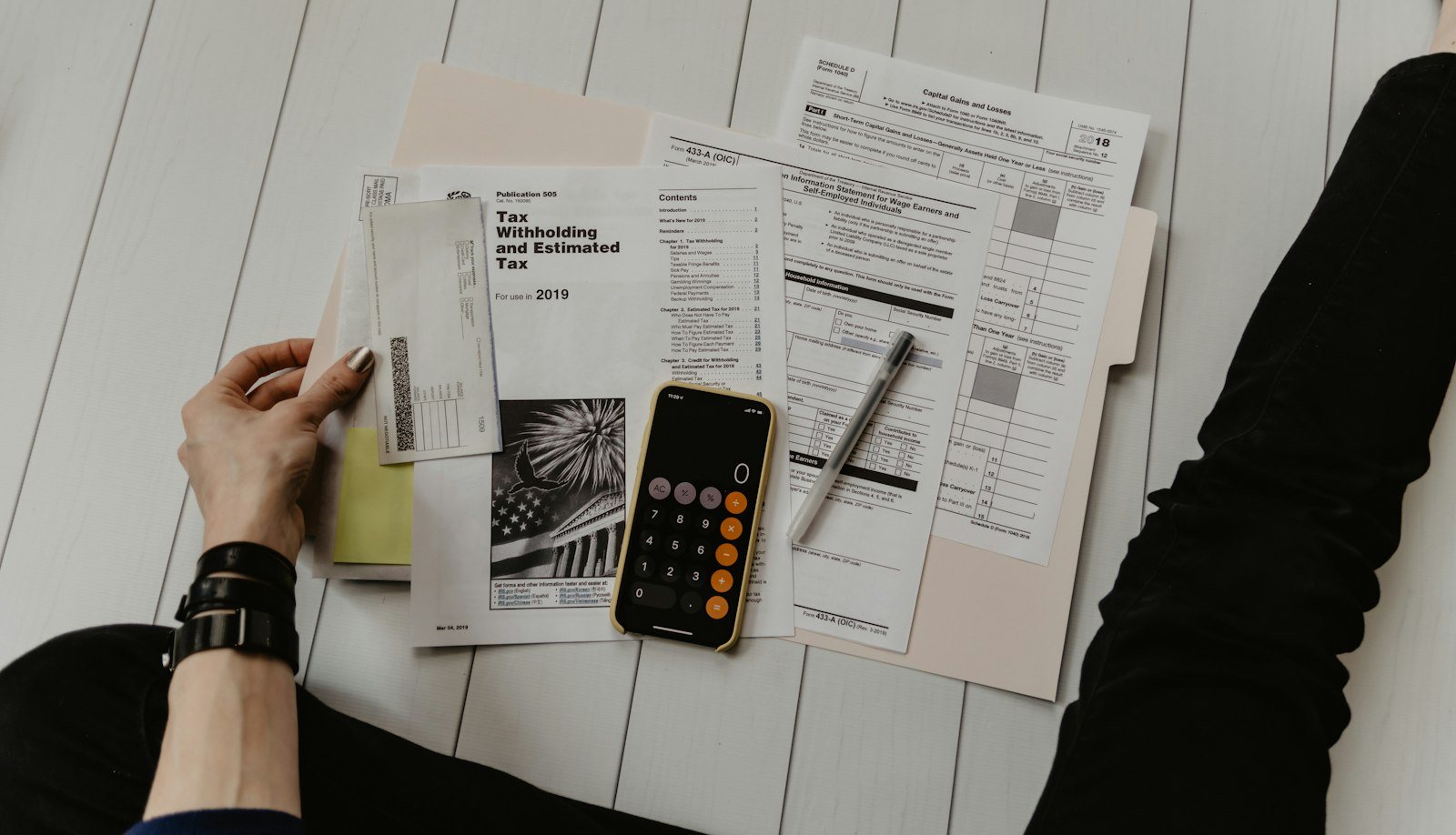Desk with tax forms, calculator, smartphone, and pen used for mortgage documentation