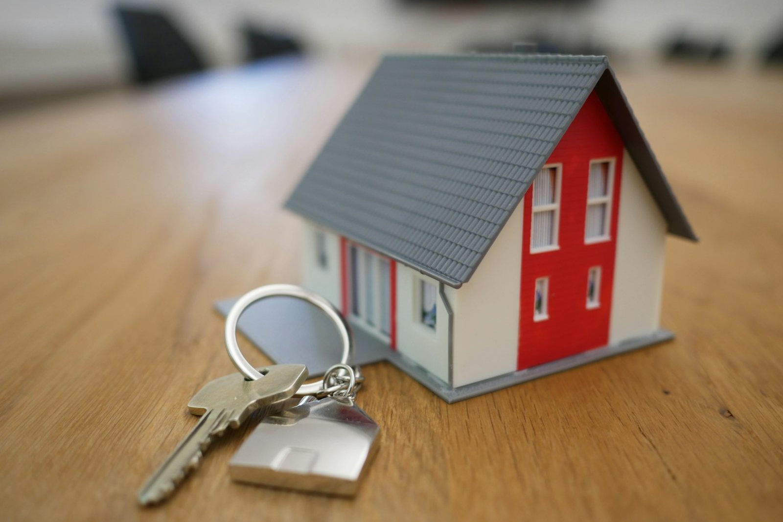 House keys on a table beside a small model home