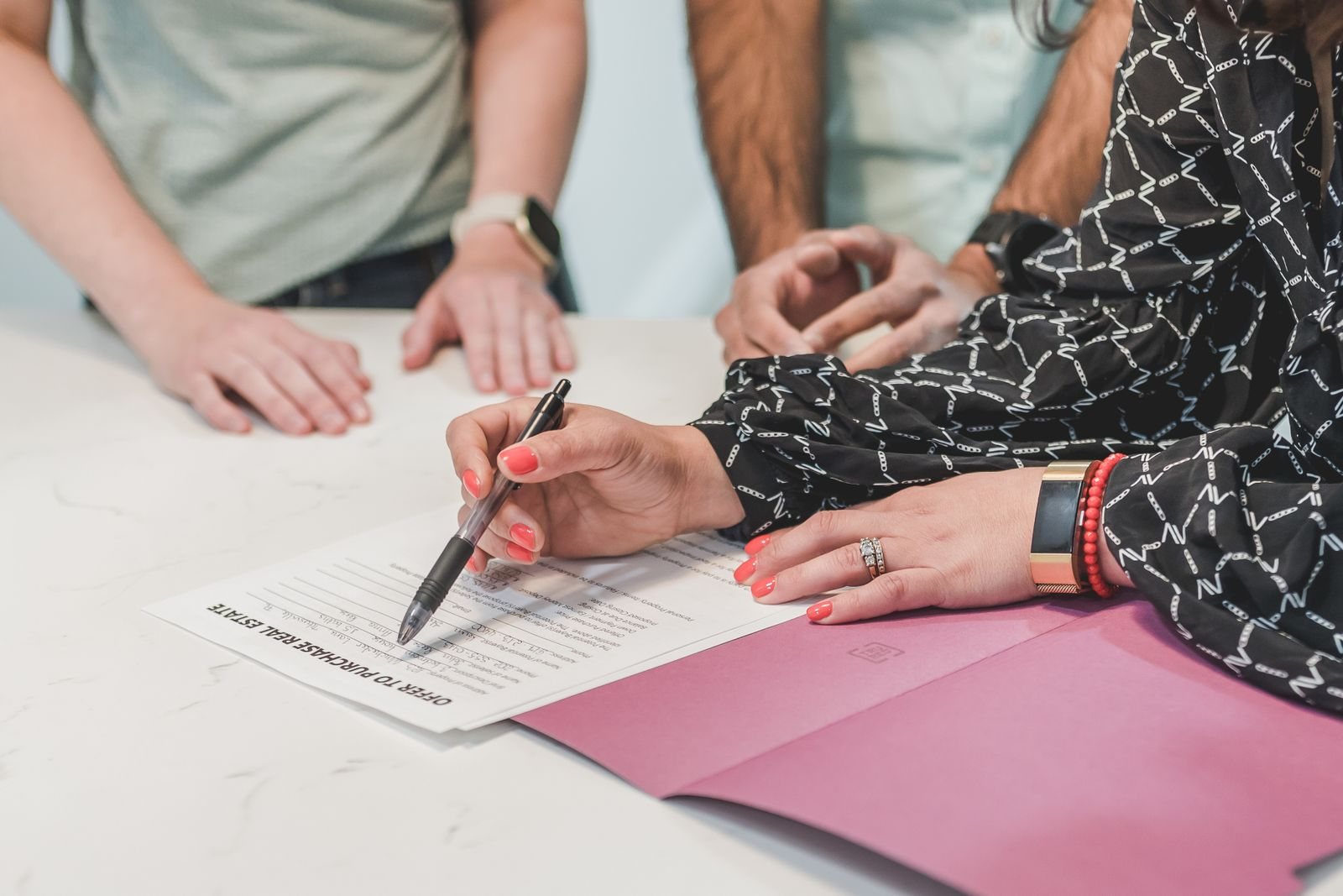 Buyer signing loan documents at a table with an advisor