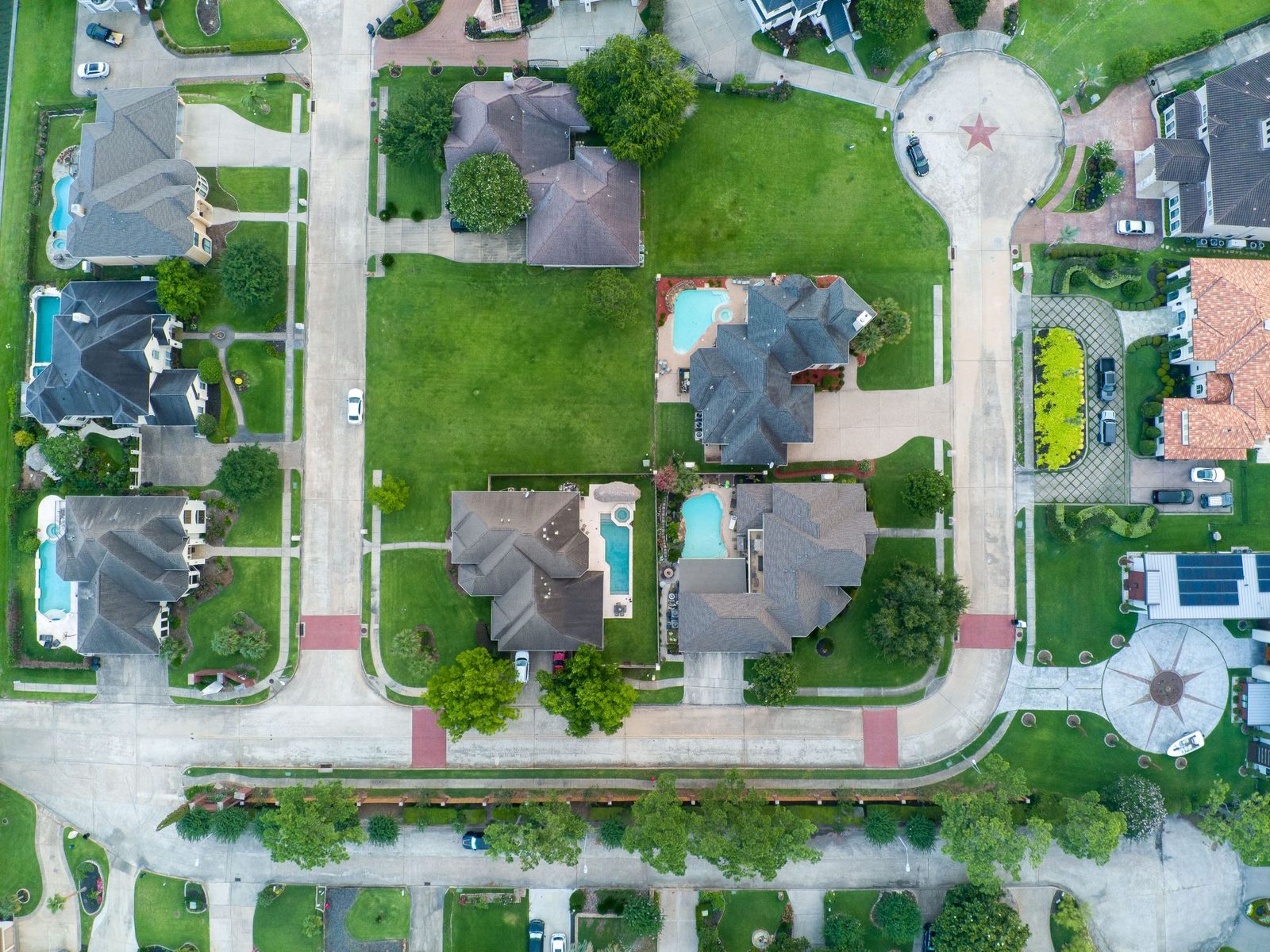 Aerial view of a Houston area suburb with tree-lined streets and rows of homes